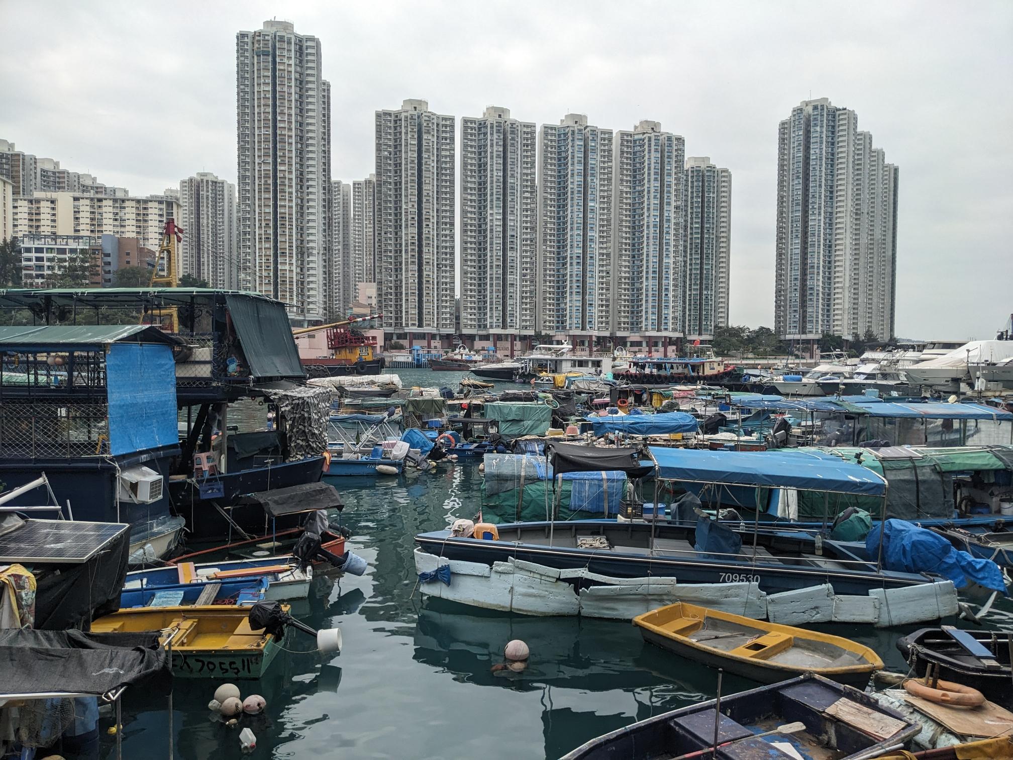 Skyscrapers behind a pier with colorful fishing boats. Skyscrapers behind a pier with colorful fishing boats.
