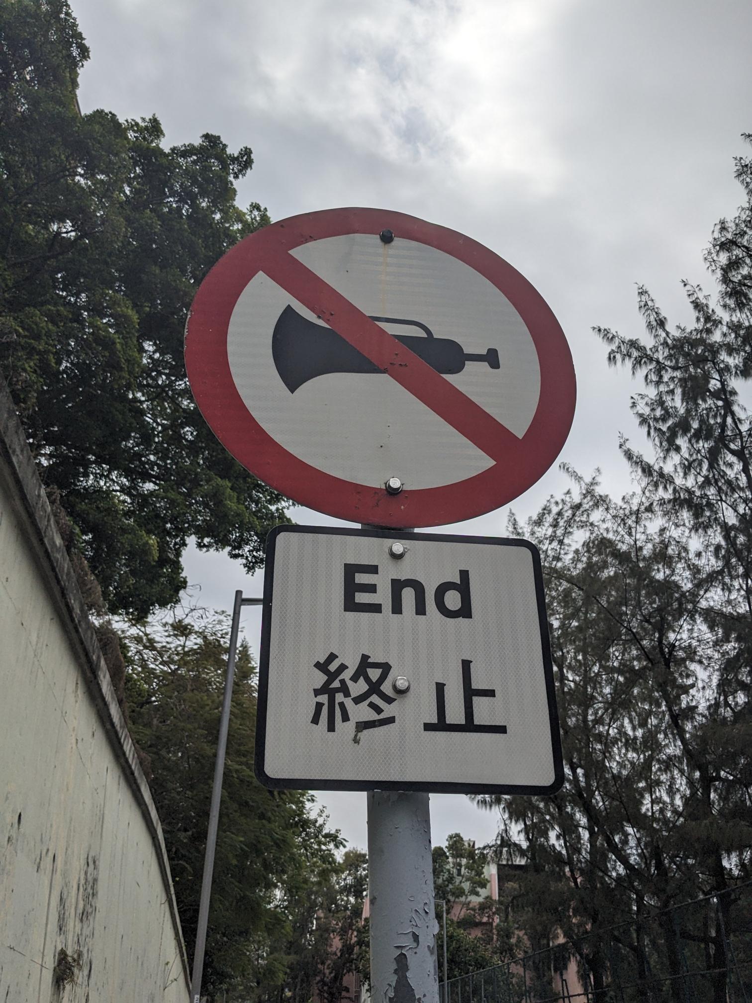 A street sign with a crossed-through air horn. A street sign with a crossed-through air horn.