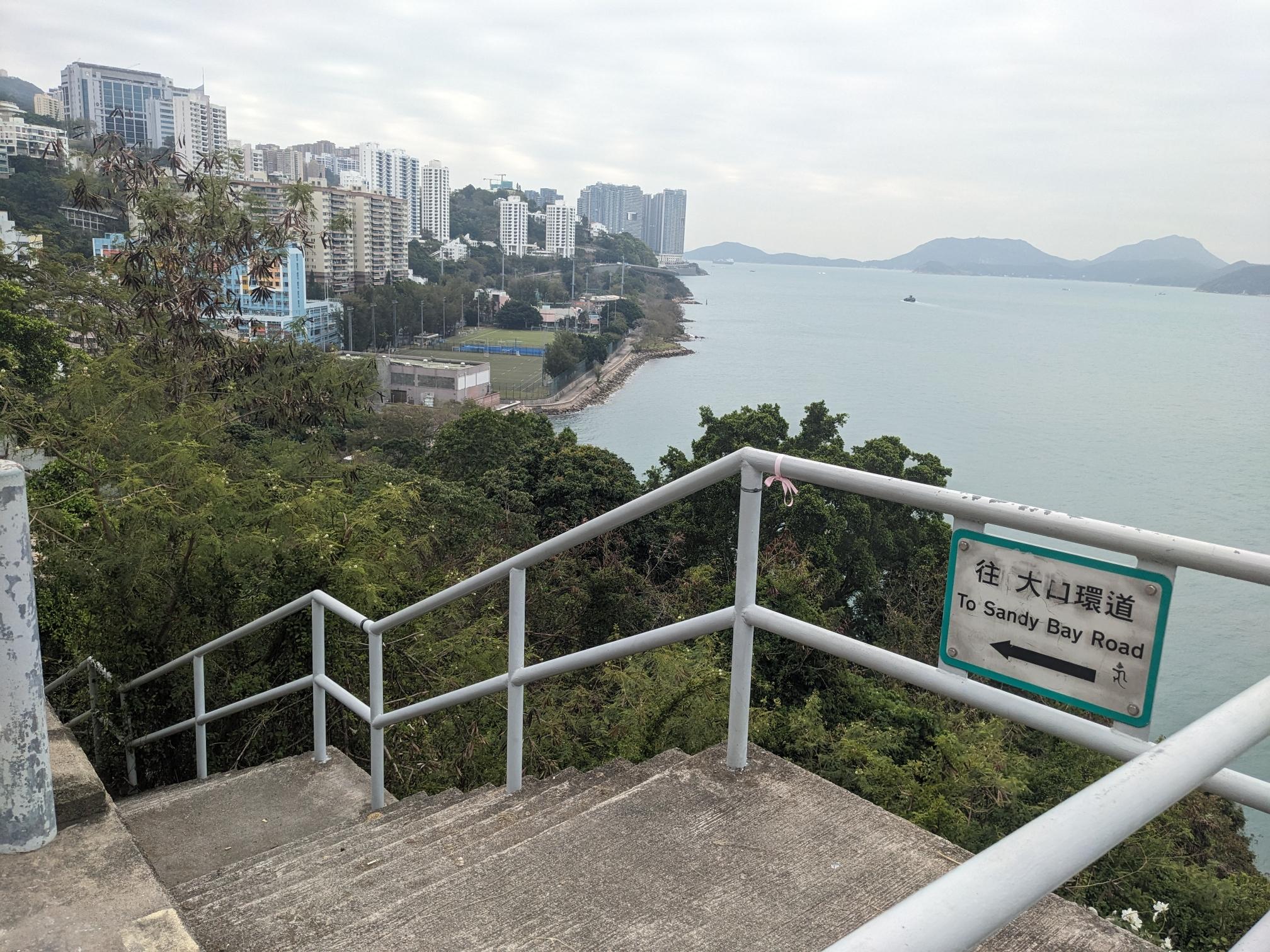 A sign pointing down a stretch of stairs: "To Sandy Bay Road" A sign pointing down a stretch of stairs: "To Sandy Bay Road"