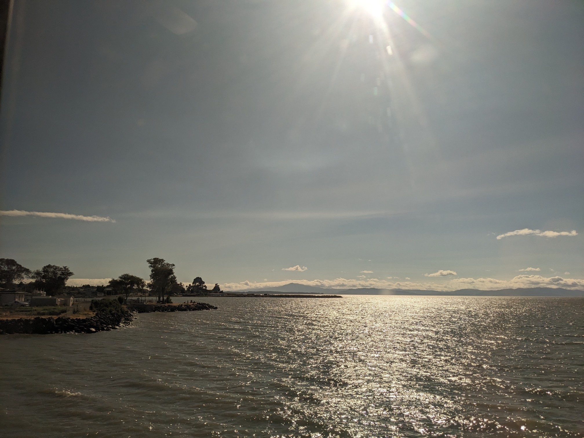 Sun over a big body of water.