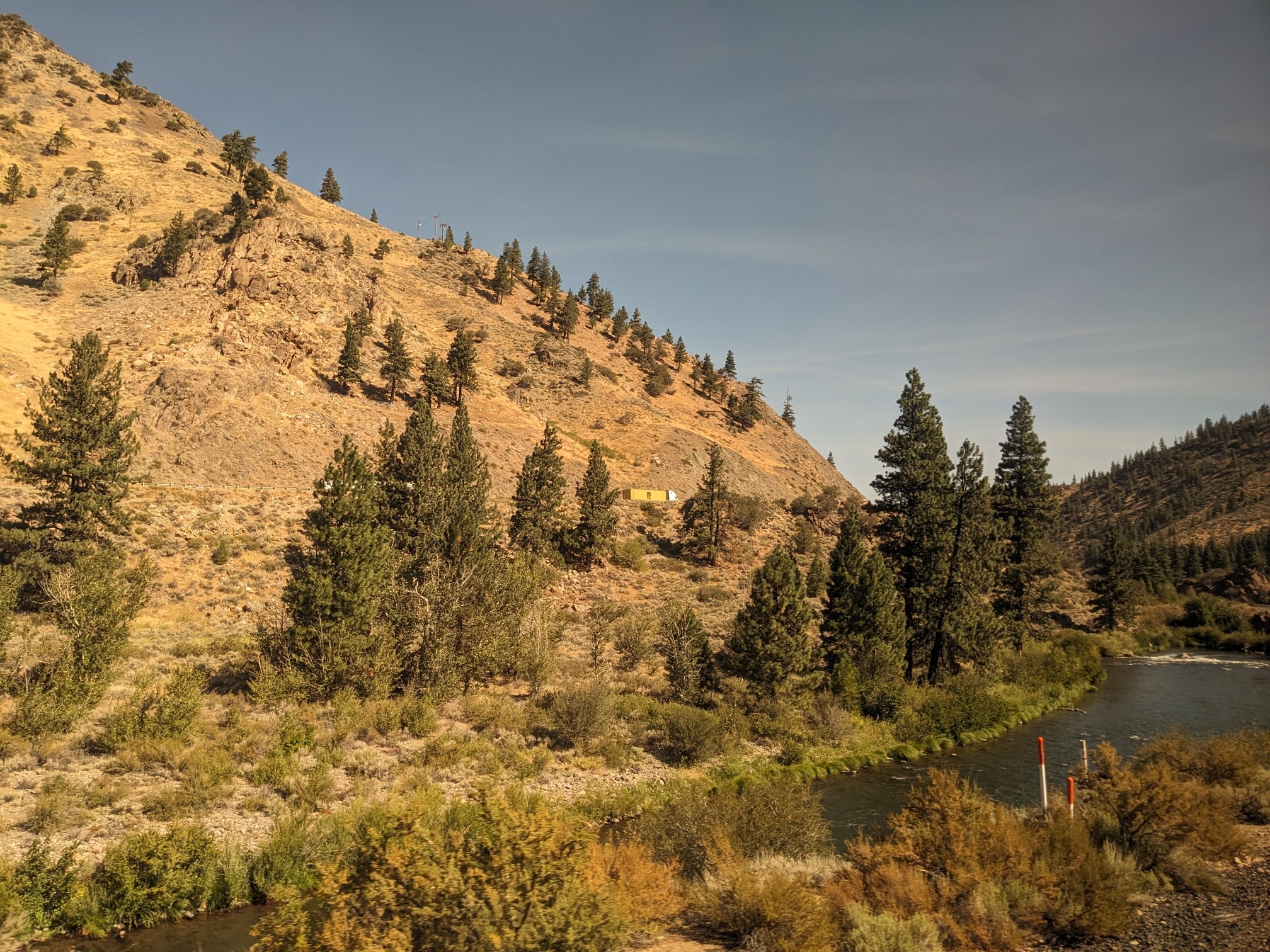 A river through hills with trees.