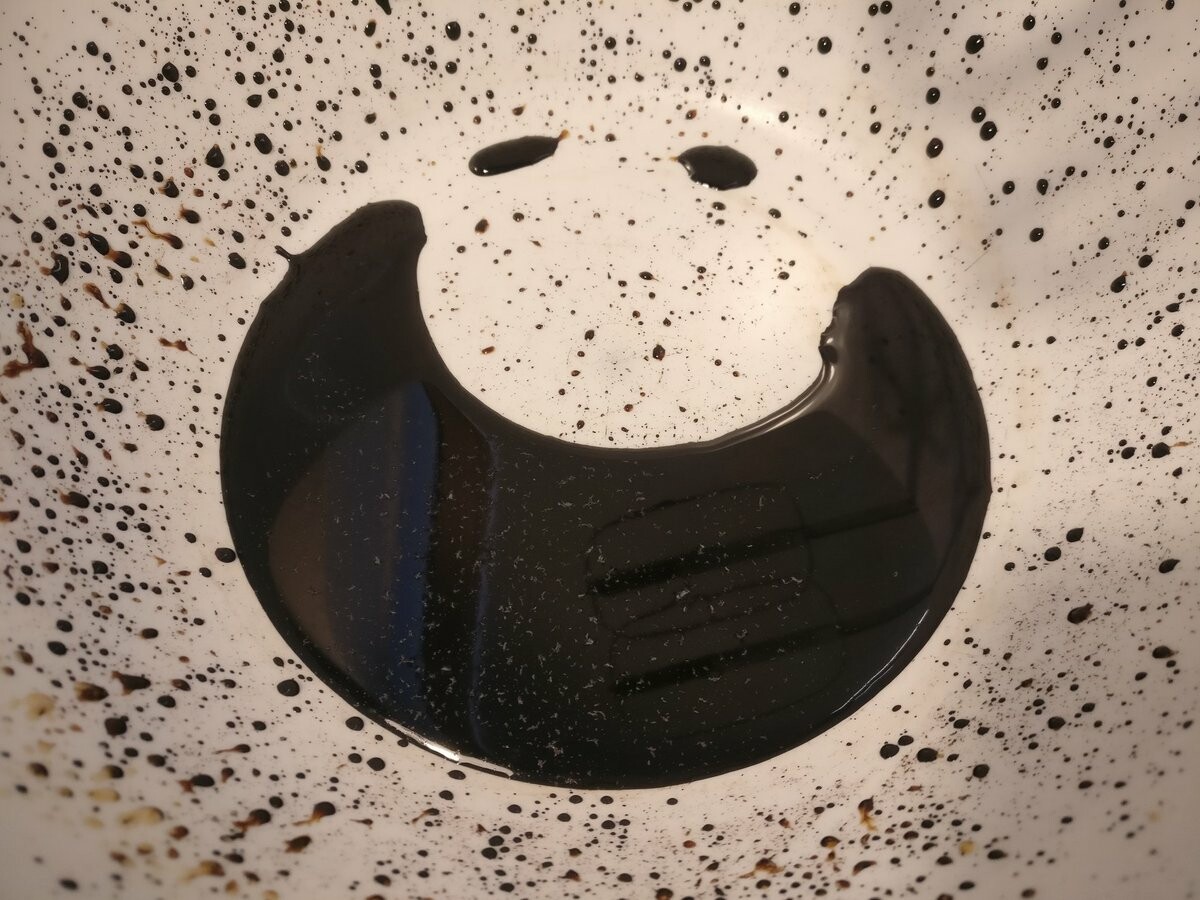 A thick dark brown liquid in a big plastic bowl. It looks a bit like a smiling face.