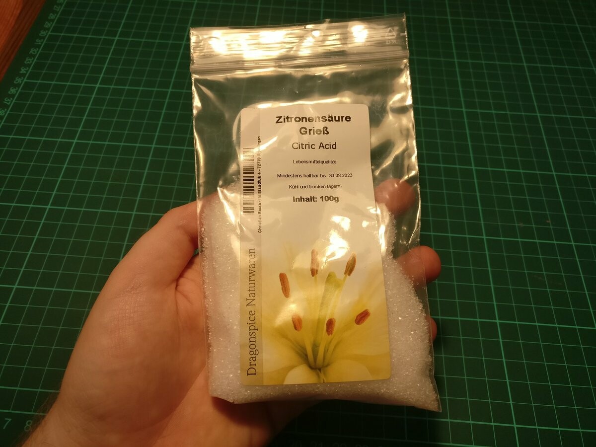 I'm holding a bag of citric acid, small transparent grains.