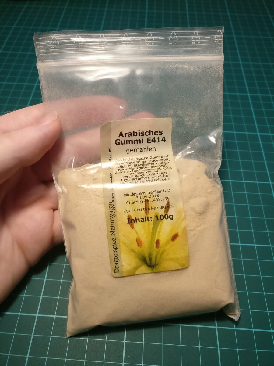 I'm holding a bag of 100 grams of ground gum arabic. It's a brown powder.