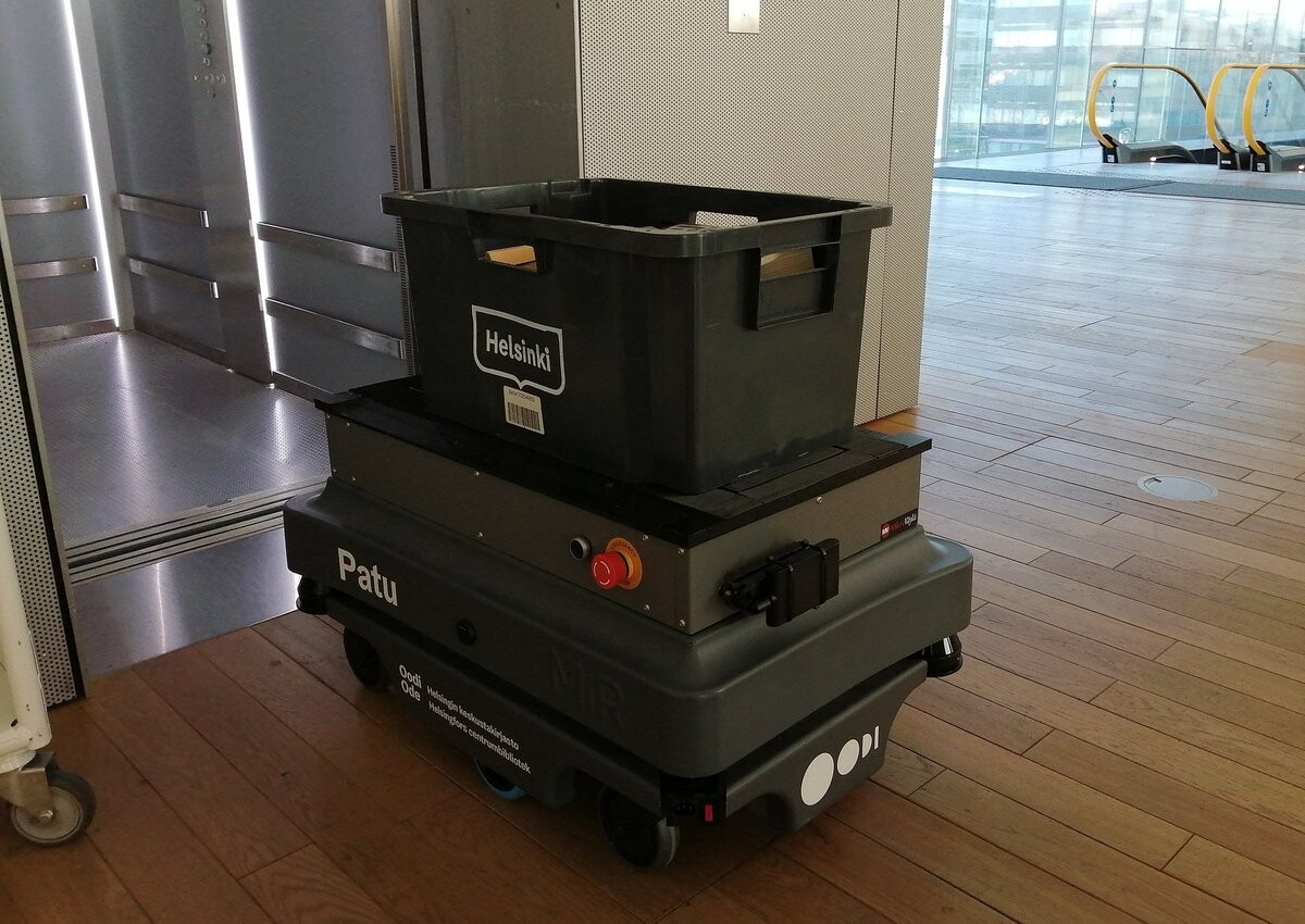 A small robot with a book bucket on top.