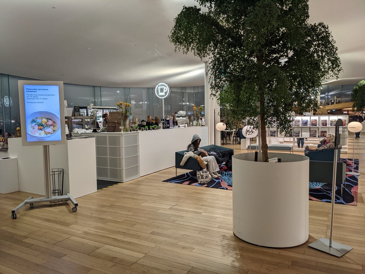 A cafe area with a small living tree besides it.