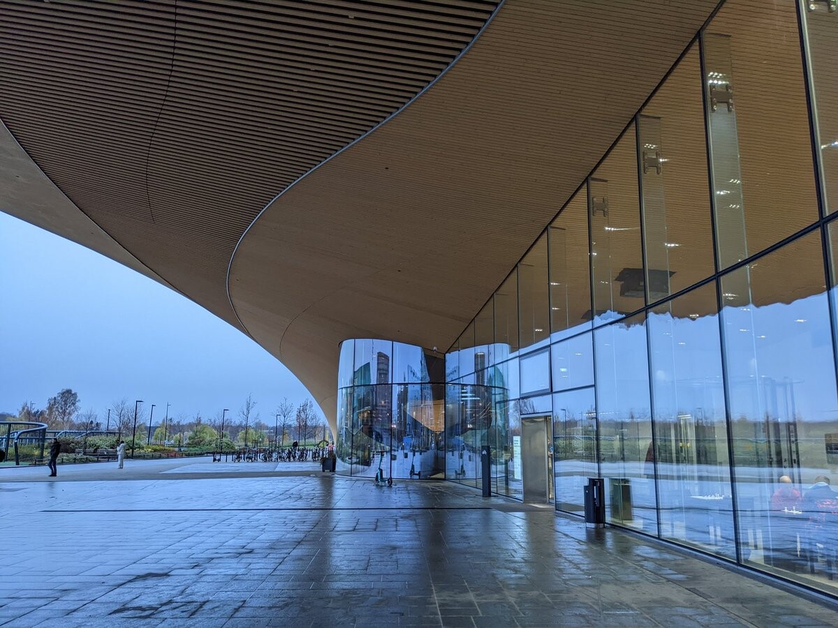 Entrance of that building, with a lot of glass.
