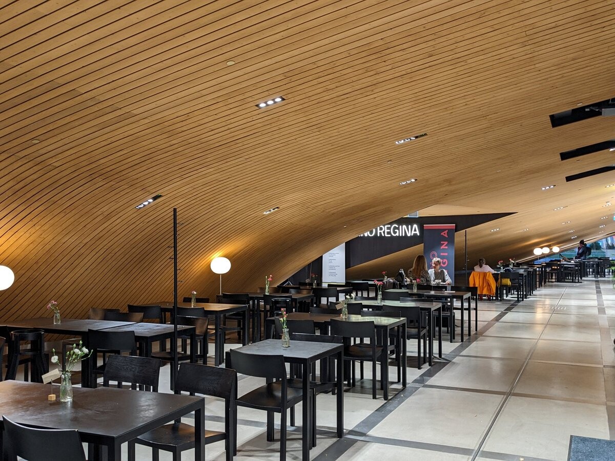 Organically-shaped ceiling over tables.